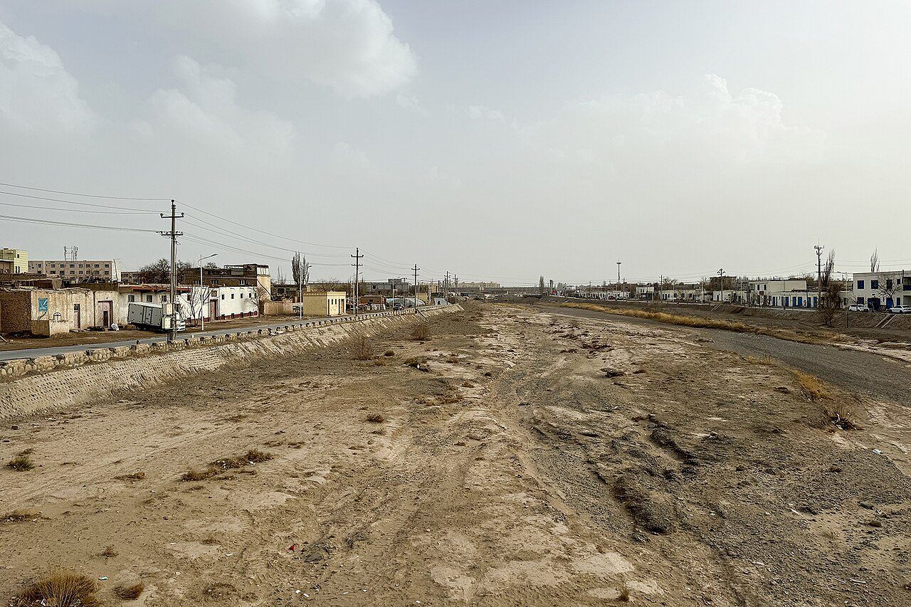 新疆库车市，干涸的库车河河床与远处的城市建筑