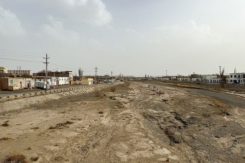 新疆库车市，干涸的库车河河床与远处的城市建筑