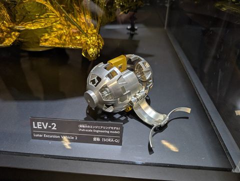 一个金属材质、双轮展开的SORA-Q模型在玻璃展柜中展出